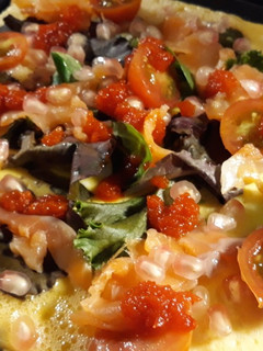 Una foto de Tortilla abierta con salmón, granada y mermelada de guindilla