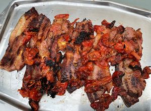 Une photo de Poitrine de porc marinée grillée aux tomates cerises