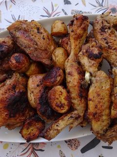 Foto de Coxas e asas de frango do campo assadas com batatinhas