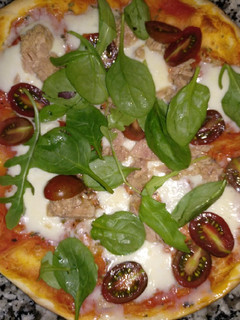 Una foto de Pizza ligera con espinacas y tomates
