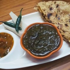 A picture of Sarso da saag te makke Di roti with tomato chutney.