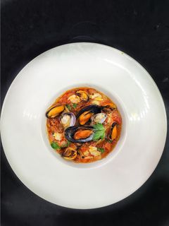 Una foto de Almejas y mejillones en salsa de tomate con chorizo