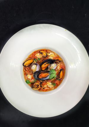 Una foto de Almejas y mejillones en salsa de tomate con chorizo