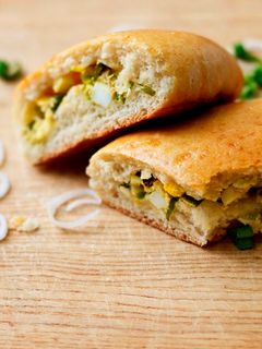 A picture of Pirozhki or Empanadas Filled with Egg and Green Onions.