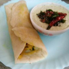 A picture of Masala dosa with coconut chutney.