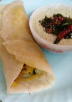 A picture of Masala dosa with coconut chutney.