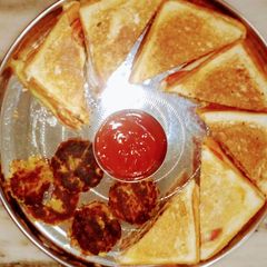 A picture of Vegetable Sandwich with sauce and aloo tikki.