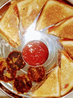A picture of Vegetable Sandwich with sauce and aloo tikki.