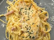 Una foto de espagueti con lonchas de queso
