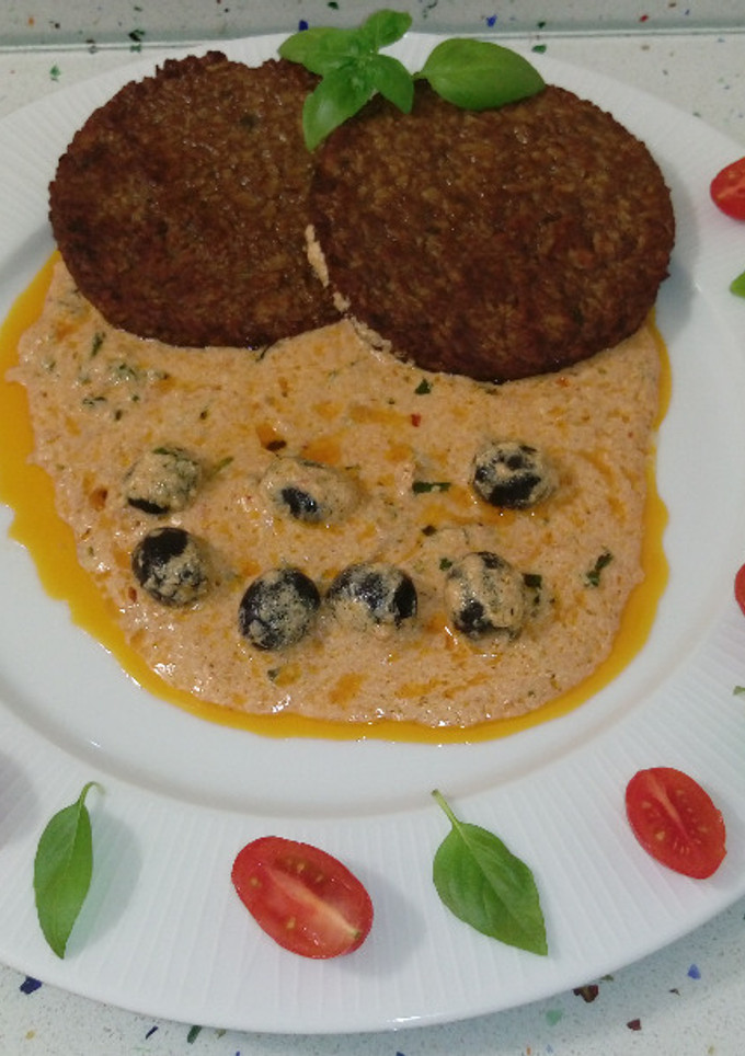 Una foto de Hamburguesas de arroz y calabacines con crema de ñoras, aceitunas y albahaca