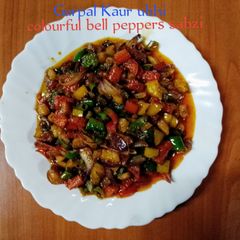 A picture of Colourful bell peppers sabzi 🍅🧅🌿🫑🌶️.