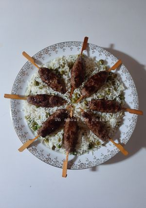A picture of Kefta Skewers on a Bed of Steamed Rice with Green Peas.