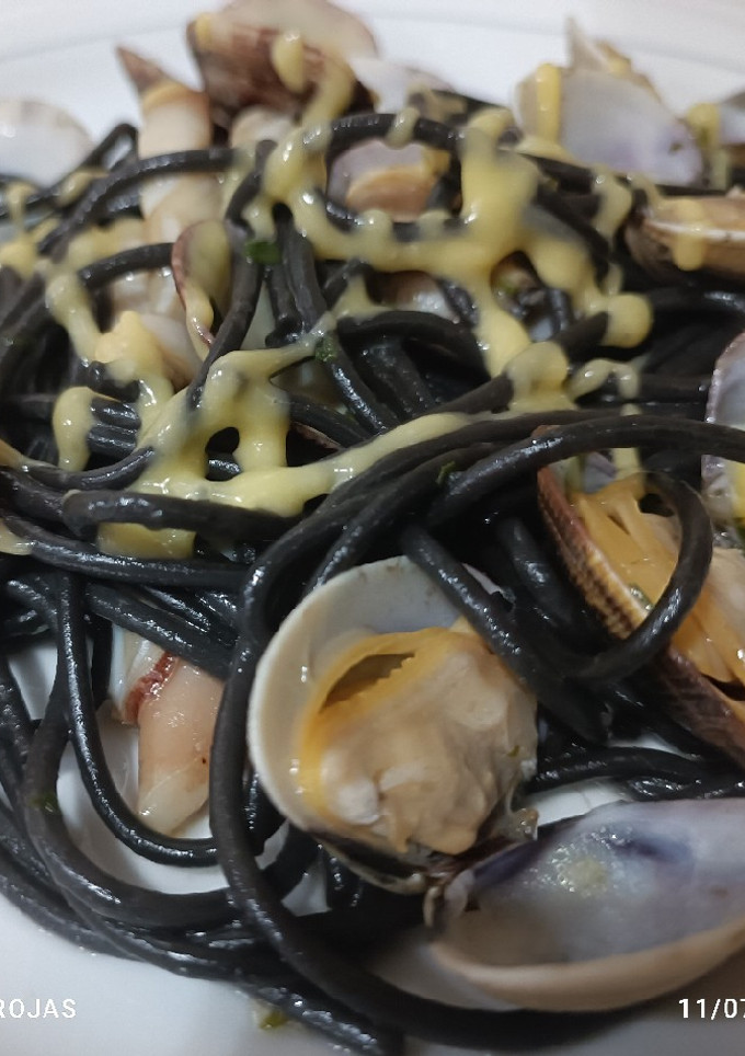 Una foto de Spaghetti negro con almejas, navajas y un punto de alioli