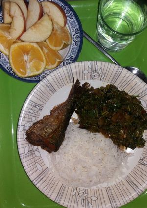 A picture of White rice with spinach and fried fish.