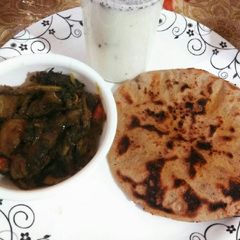 A picture of Jawar roti, buttermilk aur bengan palak.