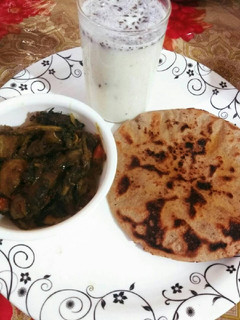 A picture of Jawar roti, buttermilk aur bengan palak.
