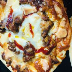 A picture of Cheesy chicken tikka pizza.