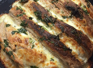 Una foto de Pan semi integral relleno con ajo muzzarella perejil y oliva