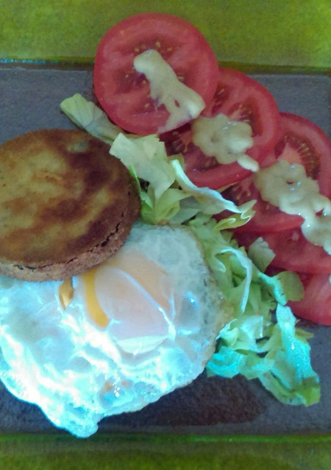 Una foto de Hamburguesa envuelta en queso con berenjena rellena, huevo frito y salsa de mostaza