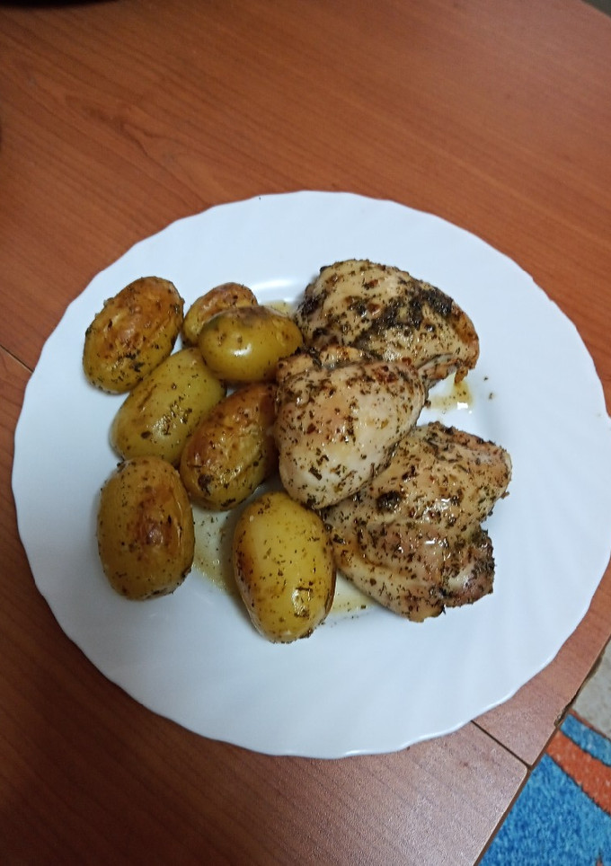 Una foto de Pollo cocido y embarrado al horno con papas asadas