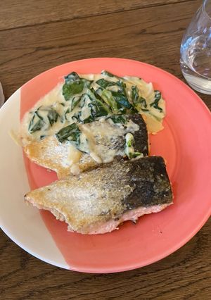 A picture of Pan fried salmon with white cream sauce.
