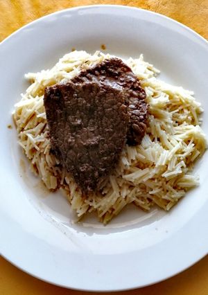 Una foto de Bistec en cama de cabellos de ángel