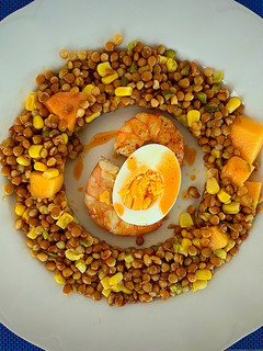 Una foto de Ensalada de lentejas, papaya, huevo, langostinos y el aliño de sus cabezas