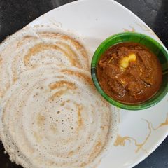 A picture of Crispy Dosa with broken egg curry.