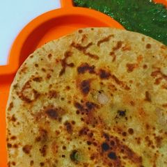 A picture of Aloo ke parathe with green chutney.