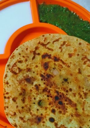 A picture of Aloo ke parathe with green chutney.