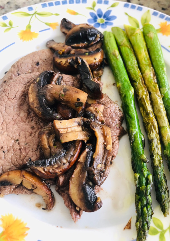 Una foto de Filete de res, con hongos baby bella y espárragos