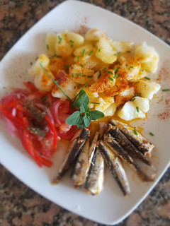Una foto de Sardinas, con papas, morrón y cebolla encurtidos