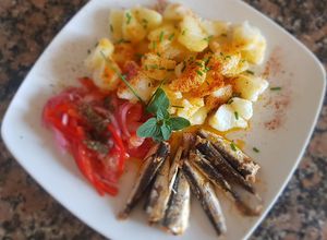 Una foto de Sardinas, con papas, morrón y cebolla encurtidos