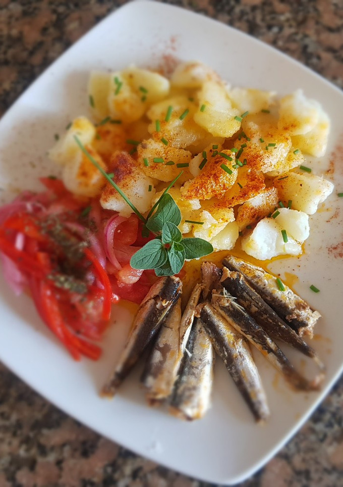 Una foto de Sardinas, con papas, morrón y cebolla encurtidos