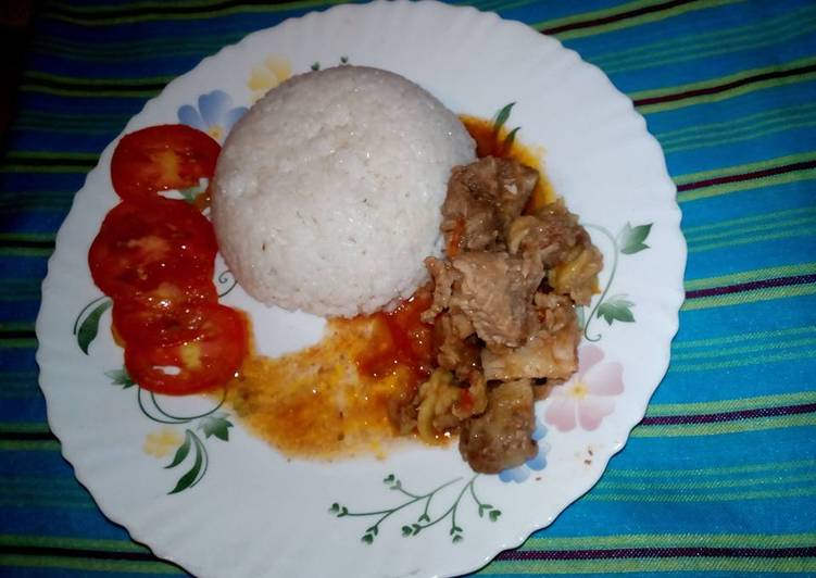 Boiled rice /beef stew garnished with tomatoes