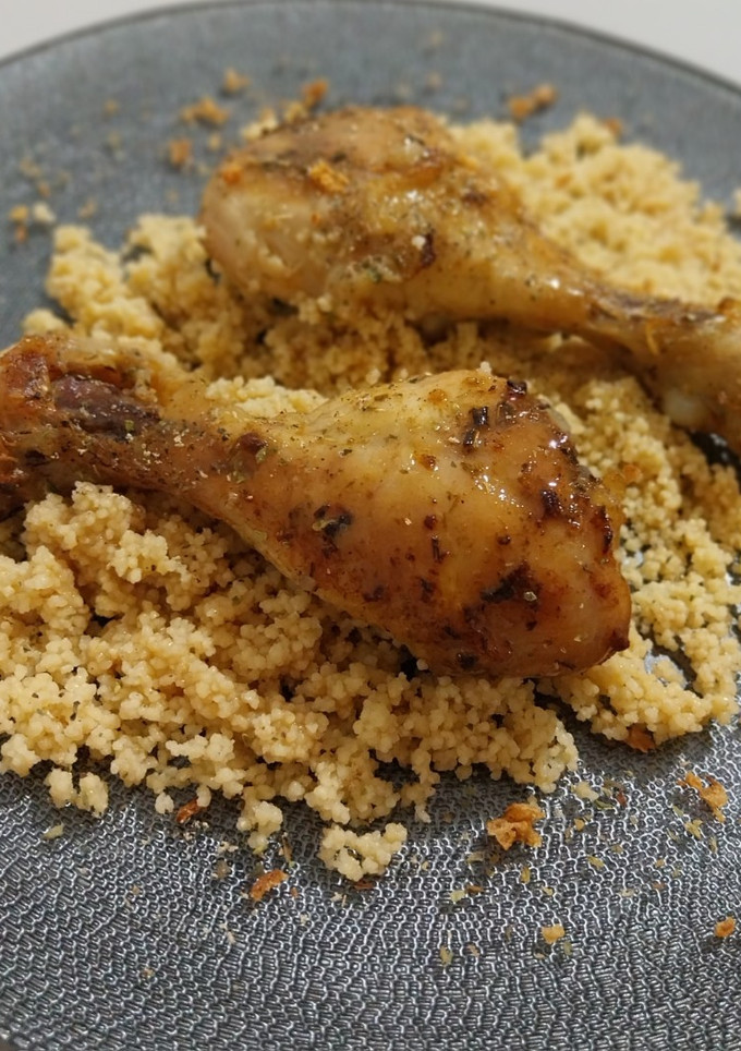 Una foto de Muslitos de pollo especiados al horno con cuscús en su jugo