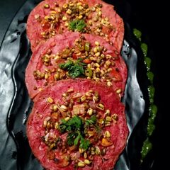 A picture of Oats chila with sprouted beans topping.
