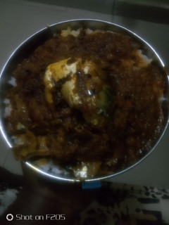 A picture of White rice with palm oil stew.
