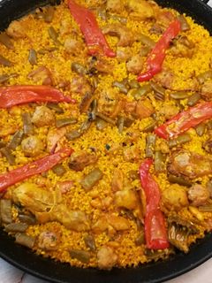 Una foto de Paella Valenciana de conejo y pollo