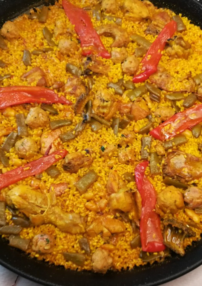 Una foto de Paella Valenciana de conejo y pollo