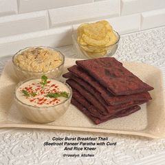 A picture of Color Burst Breakfast (Beetroot Paneer Paratha with Curd, Rice Kheer & Chips).