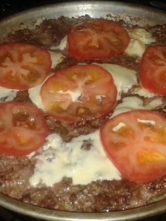 Una foto de Hamburguesa tipo pizza (con queso y tomate)
