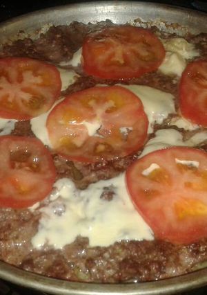 Una foto de Hamburguesa tipo pizza (con queso y tomate)