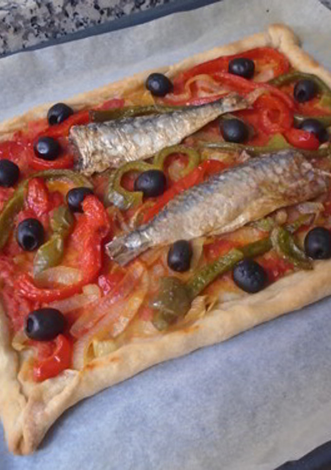 Una foto de Coca salada de pimientos y sardinas