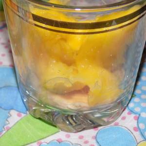 Postre en vaso con discos de pionono, crema de queso y fruta