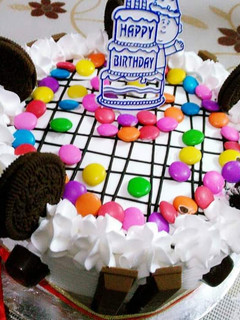 A picture of Oreo kitkat blackforest cake with vanilla flavour icing.