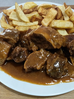 Una foto de Costillas de ternera guisada con salsa de cerveza y papas fritas