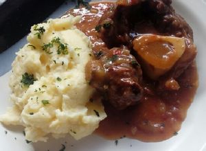 Una foto de Ossobuco braseado al vino tinto y puré cremoso