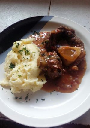 Una foto de Ossobuco braseado al vino tinto y puré cremoso