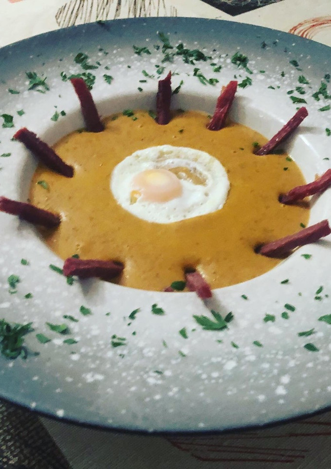 Una foto de Crema de lentejas con crujiente de jamón y huevo de codorniz en lékué